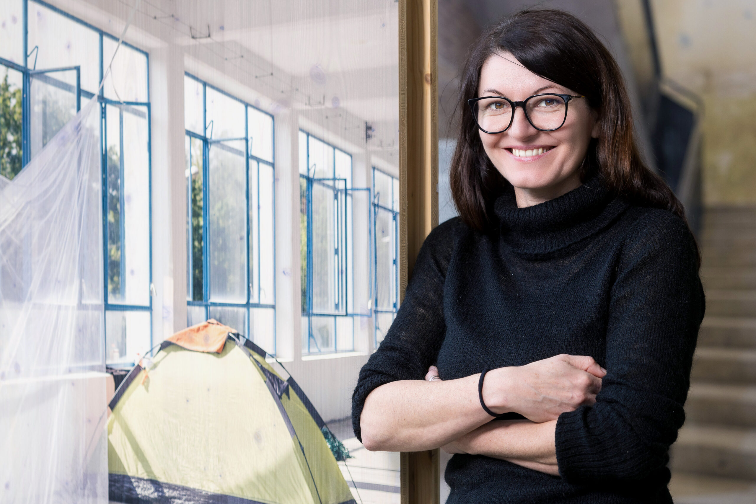 Portrait von Julia Eschment, die an einem Bild im Eiermannbau Apolda lehnt.
